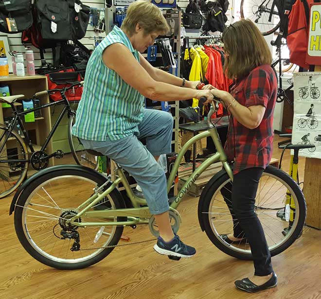 Gwen is checking the seat height with Susan, the Blue Heron Bike Shop owner