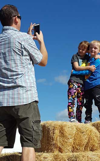 Playing on the hay stack at the pumpkin patch