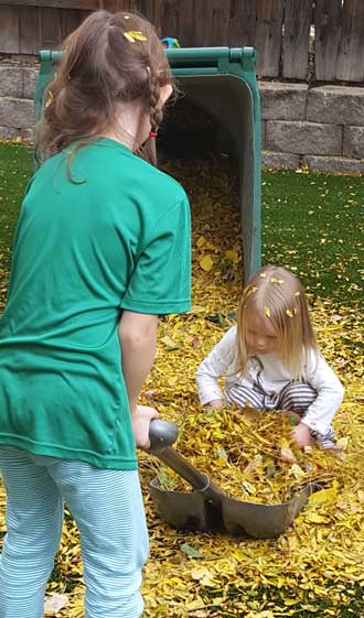 Chloe and cousin Lucy helping dad with the leaves