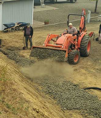 Spreading drain rock continues