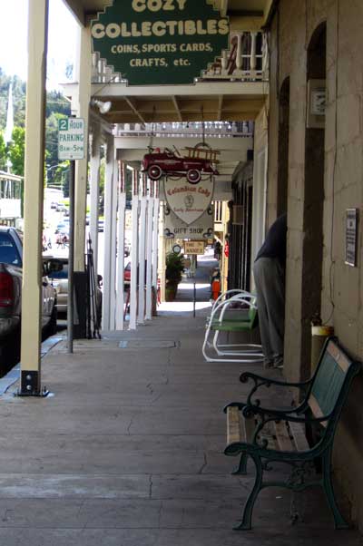 Narrow sidewale of Sutter Creek, behind: Bus clears the buildings by only inches ... such a challenge