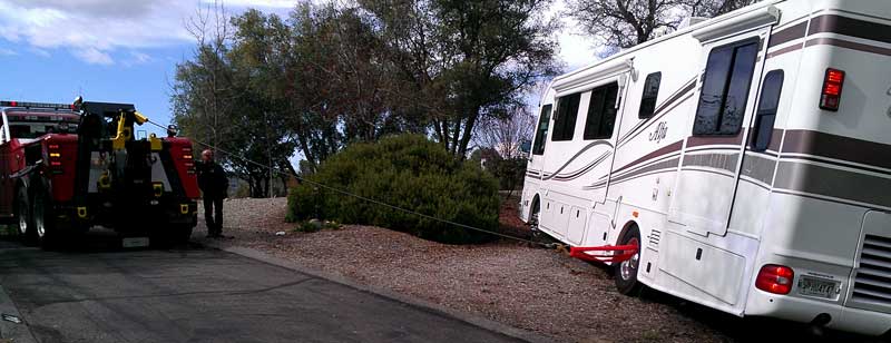 Tow truck hooks to a rear wheel to pull the coach sideways