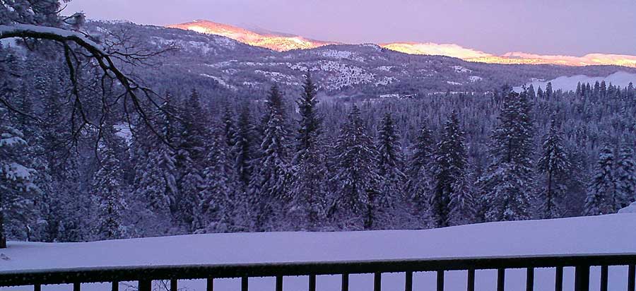 Evening view out the back door with sun blazing on the hills