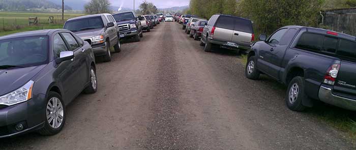 Probably 200 cars parked on this narrow dirt road