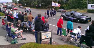 The first car in the parade with honor guard behind