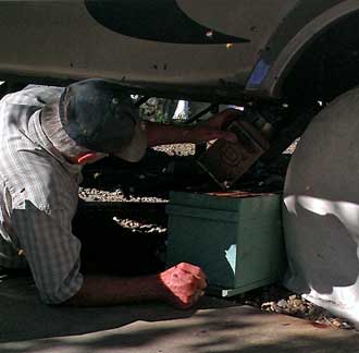 Mike prepares a box with frames to invite the bees home while gassing them to encourage evacuation of the trailer.