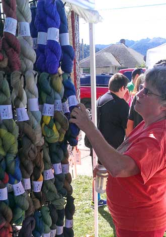 Carole inspect yarn while Jack and I look at the car show, Behind: Lots of shopping booths 