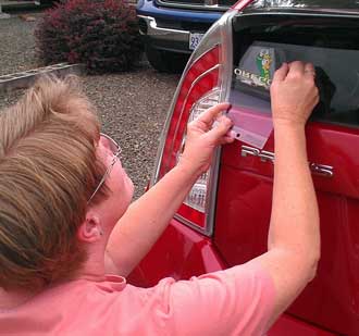 Gwen applies her Oregon Ducks decal, Behind: Gwen finishes her application 