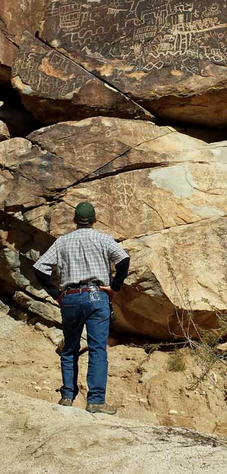 I examine some canyon petroglyphs, Behind: at larger view