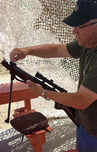 Bill teaches me how to load a pellet rifle, Behind: view of the air-gun range