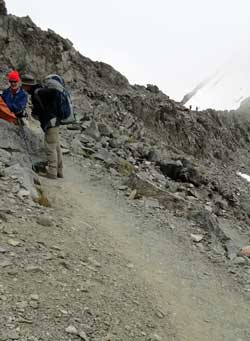 Only feet from the summit, Behind: Merle photographs the north side of Glen Pass