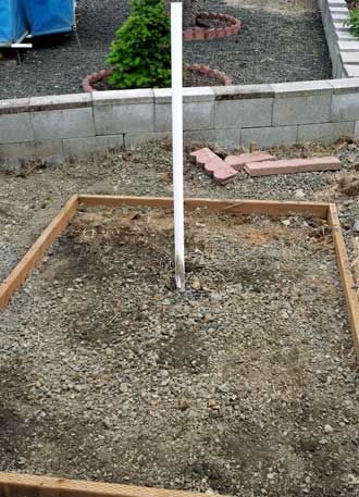 Support pole in a bucket of cement, Behind: first pavers down