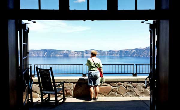 Gwen is on the lodge deck, behind: chipping the rocks off a steep cliff