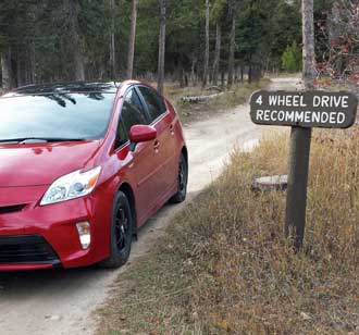 The Prius on a rough road, Behind: Wilderness cabin at the Alaska Basin Junction