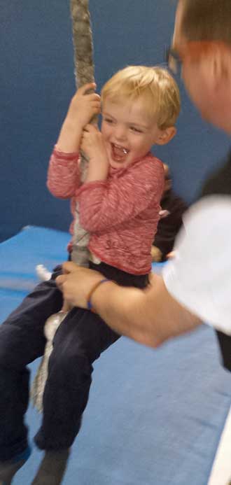 Noah on the swingiing rope, Behind: at the top of a bounce slide