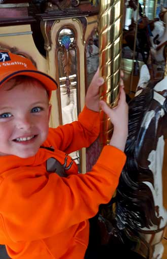 Noah is all smiles riding a carousel horse