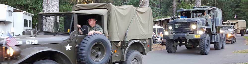 Antique military vehicles are paraded through Forth Stevens State Park
