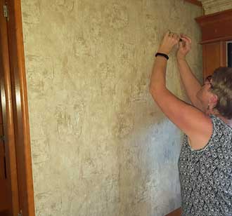 Gwen is cleaning the wall where the mirrors where at one time.