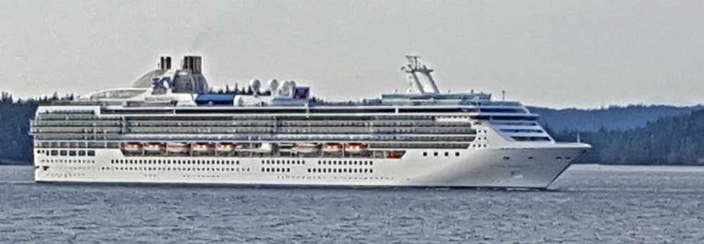 The Island Princess sails in front of camp