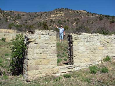 Gwen points the way to the top of the hill where there are more foundations. 