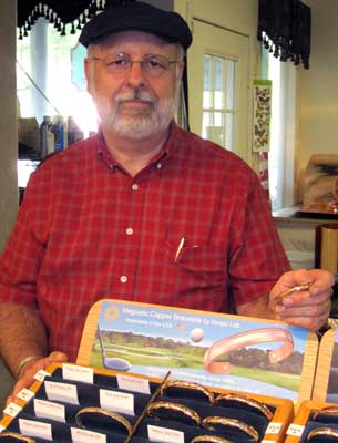 Greg, the owner of the Copper shop is holding the gift I bought for Gwen