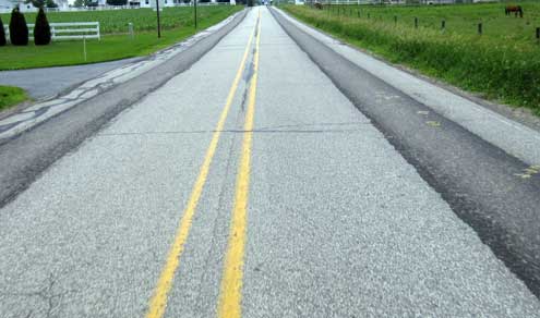 Repaired pavement worn from one horse carriages.