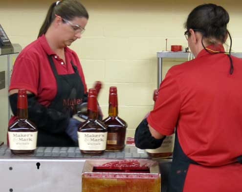 Hand dipping each bottle top in wax, a Maker's Mark trademark
